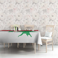 White tablecloth with red stripe and green cedar graphic on dining table