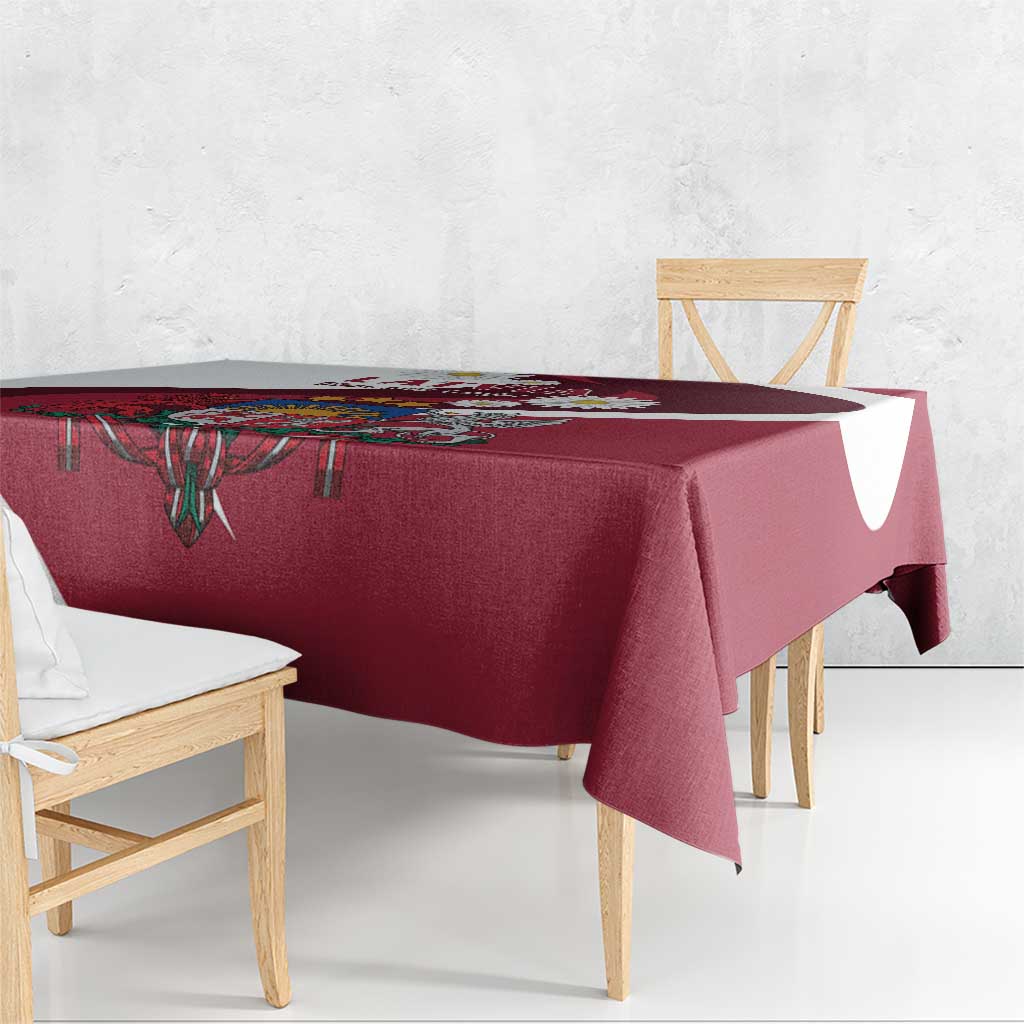 Red tablecloth with crest medallion and patterned border on table