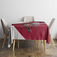 Red tablecloth on dining table with central crest motif and draped sides