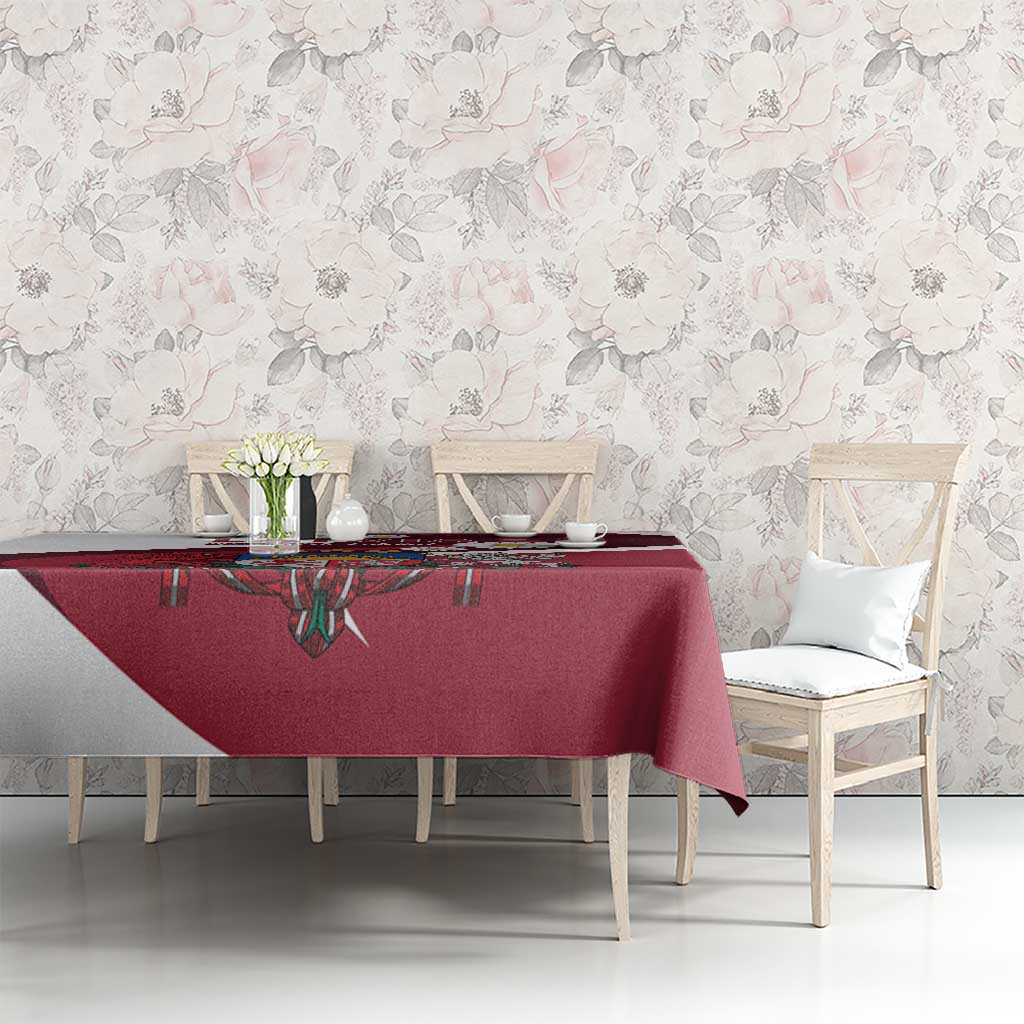Red tablecloth on dining table featuring crest design and daisy accents