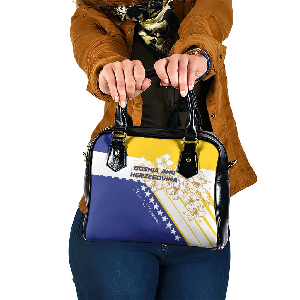 Shoulder handbag with black handles, blue-and-yellow flag panel and gold lily emblem
