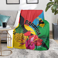 Tropical blanket draped on sofa with birds, pineapples, hibiscus flowers, and BARBUDA