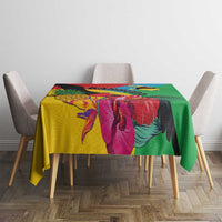Colorful tropical tablecloth over table with green edge and bird-and-leaf artwork