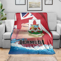 Red, white, and blue Bermuda-themed blanket on a couch, featuring crest emblem and waves