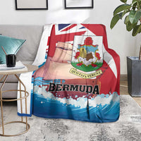 Red, white, and blue Bermuda-themed blanket over a gray sofa, crest emblem centered