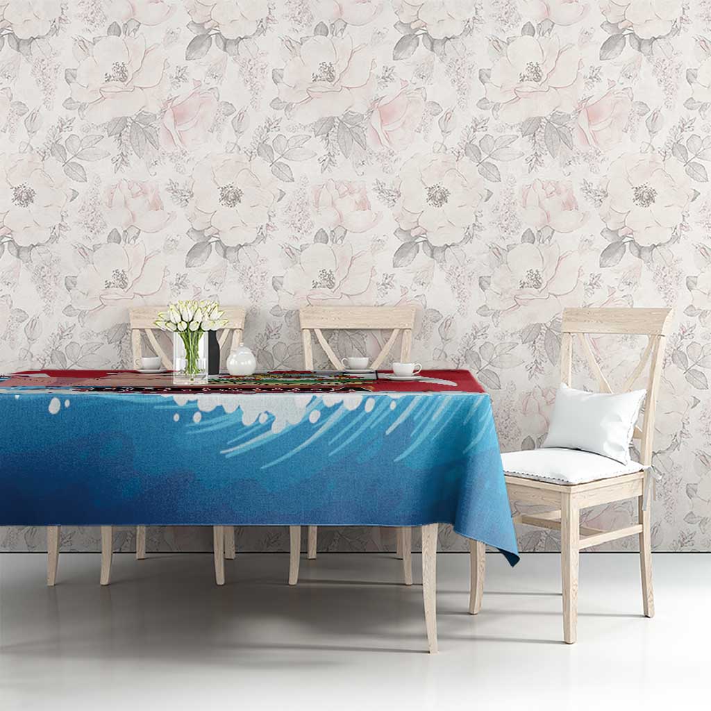 Red and blue wave-pattern tablecloth on dining table with white chairs and vase
