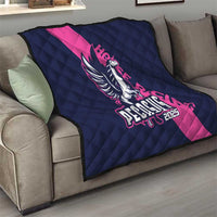 Navy and pink Pegasus 2025 quilt on sofa, diamond-quilted with logo centered.