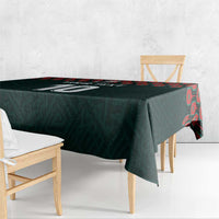 Dark green tablecloth with patterned hem and corner graphic on dining bench