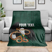 Green throw blanket on sofa with eagle-and-serpent graphic and 'YOUR TEXT' text.