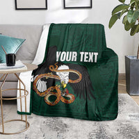 Green throw blanket with eagle-and-serpent graphic and 'YOUR TEXT' text on surface.