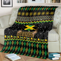 Black throw blanket draped on sofa, featuring Jamaica Christmas lion and cross in green/yellow