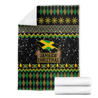 Black Christmas blanket folded with gold star row, Jamaica graphic, and green diamond design