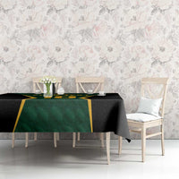 Green and black cricket tablecloth with gold border on dining table setting