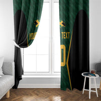 Green and black window curtains with gold jersey design, one side tied back on a white window