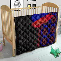 African flag-style quilt in nursery crib, black with blue and red diagonal stripe and rings