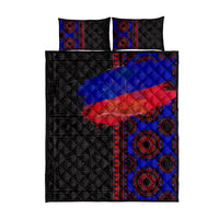 Quilt bed set flat lay: black quilt with blue-red Haiti flag panel and circular motifs
