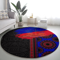 Round area rug featuring black, red, and blue concentric pattern with central banner