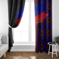 Window curtain panels hanging beside a door, black drape on left and blue/red medallions on right