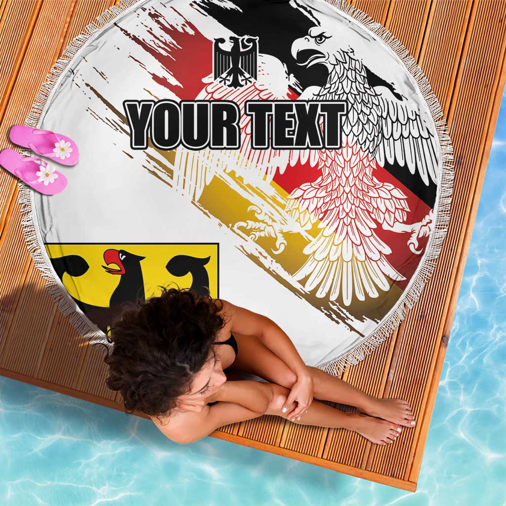 Round beach blanket with white background, eagle wings graphic, red and yellow bands