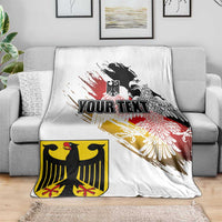 White blanket on gray sofa with black eagle crest, red-yellow grunge print, 'YOUR TEXT'.