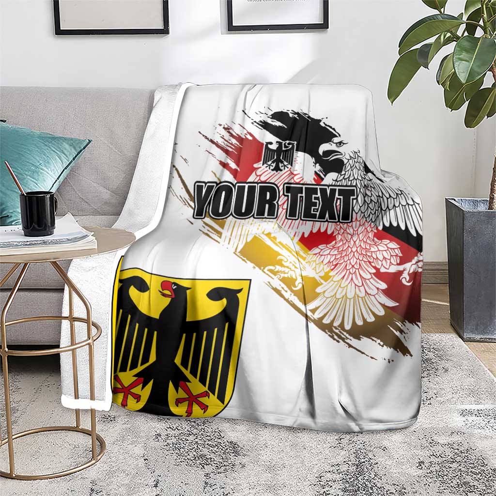 White blanket draped on gray sofa with black eagle crest over red-yellow grunge flag design.