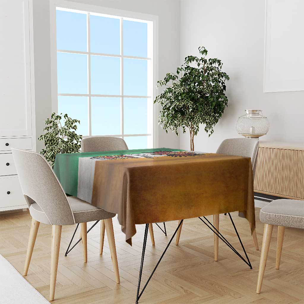 Grunge-style rectangular tablecloth covering dining table; green, brown, and gray with tattoo emblem