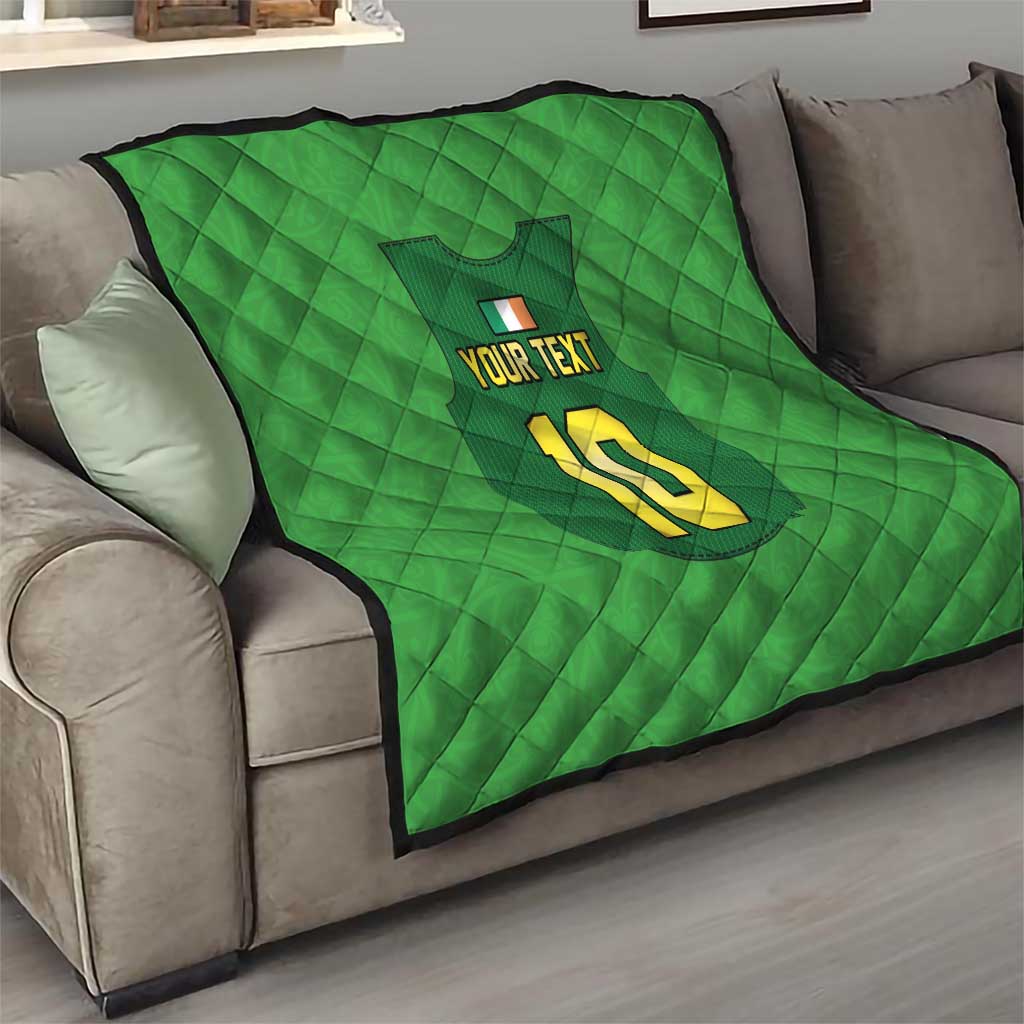 Green custom quilt draped on a sofa, with crest, “YOUR TEXT”, and yellow “10”.