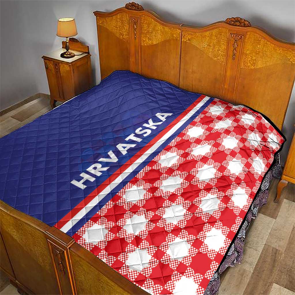 Blue and red check quilt laid on bed, HRVATSKA stripe along the seam