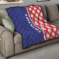 Blue and red check quilt on a sofa with HRVATSKA stripe and quilted diamonds