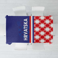 Folded blue tablecloth half with 'HRVATSKA' text and red checkered half