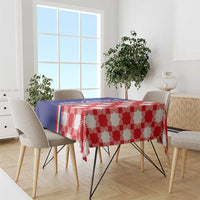 Red checkered tablecloth with blue edge stripe, covering dining table with chairs