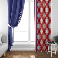 Blue window curtain partially tied open beside a red-and-white checkerboard curtain