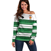 Women’s off-shoulder rugby sweater in white with green stripe pattern and chest emblem
