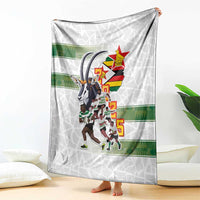 White rugby blanket with Zimbabwe team crest, players illustration, and green band