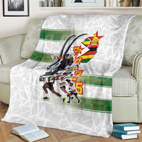 White rugby blanket with Zimbabwe Warriors crest and green stripe, draped view