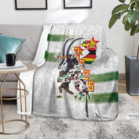 White rugby blanket with Zimbabwe Warriors players graphic and green band