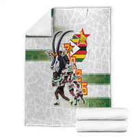 Folded white rugby blanket with Zimbabwe Warriors graphic and green stripe