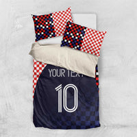 Bedding set laid flat: red-and-white checker pillowcases and navy duvet with custom text and number 10