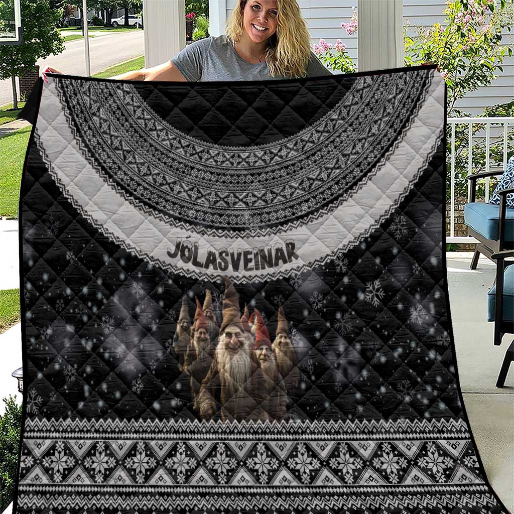 Black Nordic quilt with gray patterned border, gnome-like figures, and diamond quilting