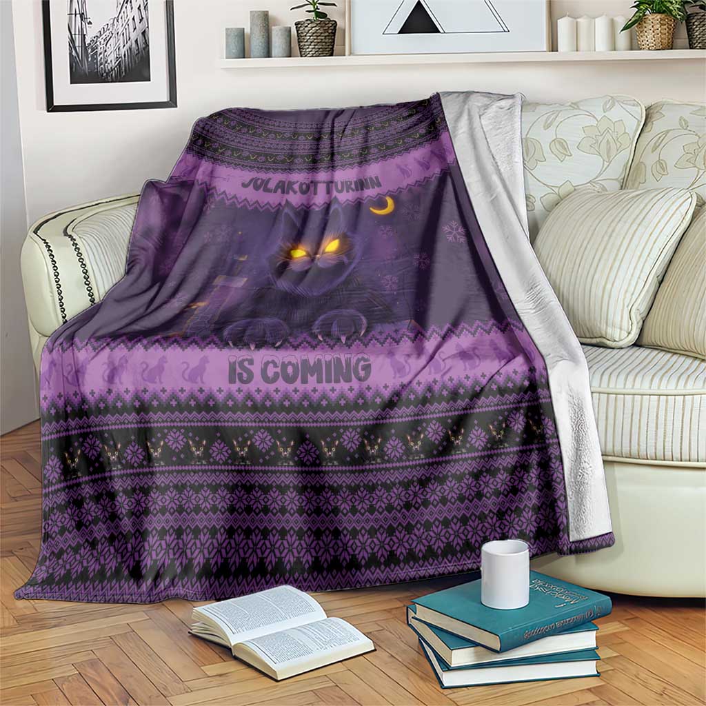 Dark purple Christmas blanket with glowing cat face and Nordic patterned stripes, fringed edge