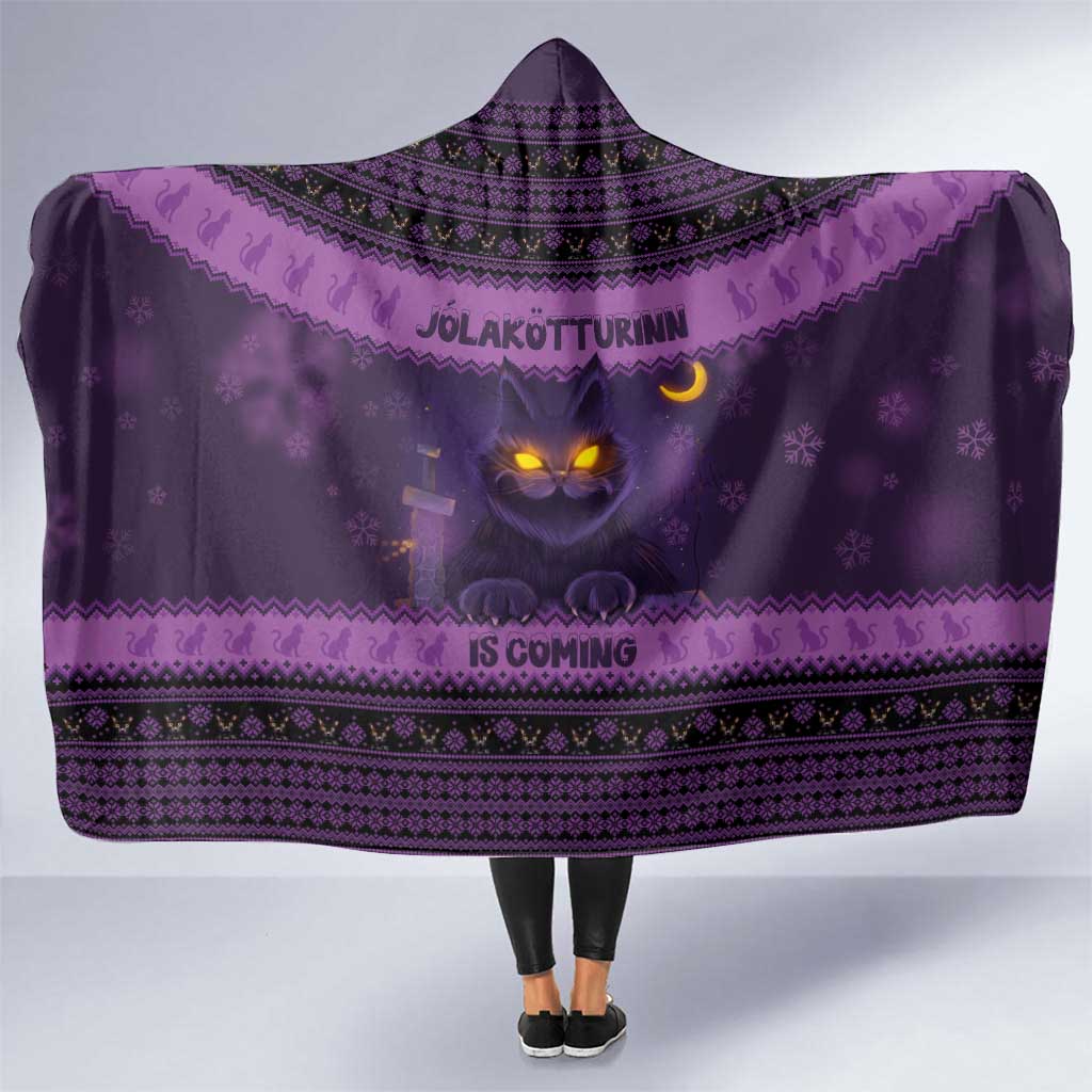 Dark purple hooded blanket with yule cat face and Nordic-style pattern, front view