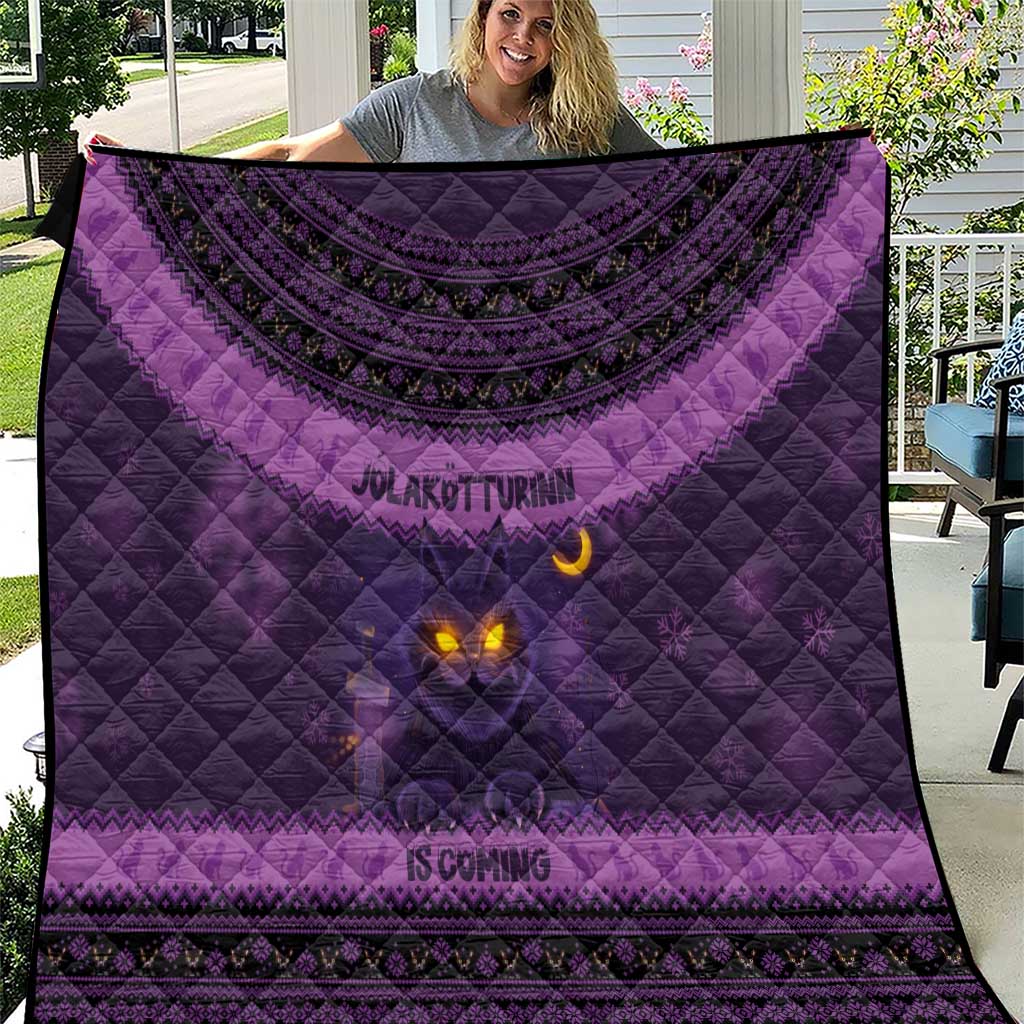Dark purple quilt blanket with Nordic pattern border and glowing cat face design