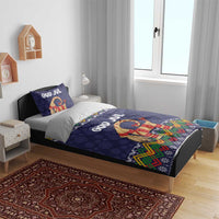 Dark blue duvet on wooden bed with 'GOD JUL' and red goat print plus colorful folk border