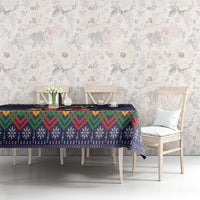 Dark blue tablecloth with colorful folk border over dining table, zigzag and snow motifs