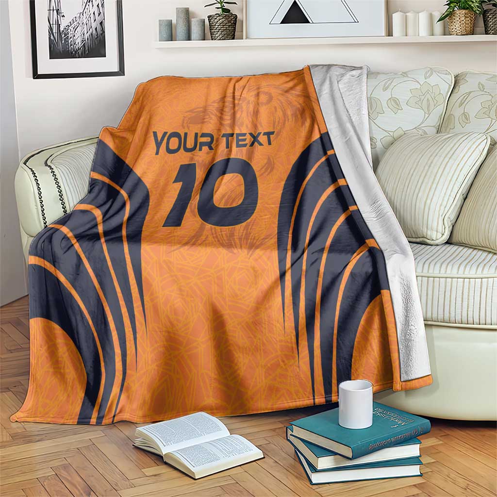 Orange fleece blanket with navy number 10, “YOUR TEXT” and curved stripe pattern