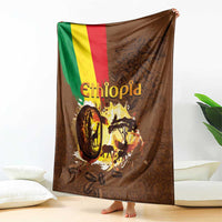 Deep brown Ethiopia blanket draped over bed, flag stripe and coffee-wildlife print