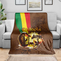 Deep brown Ethiopia blanket on gray sofa, flag stripe and coffee-themed animals print