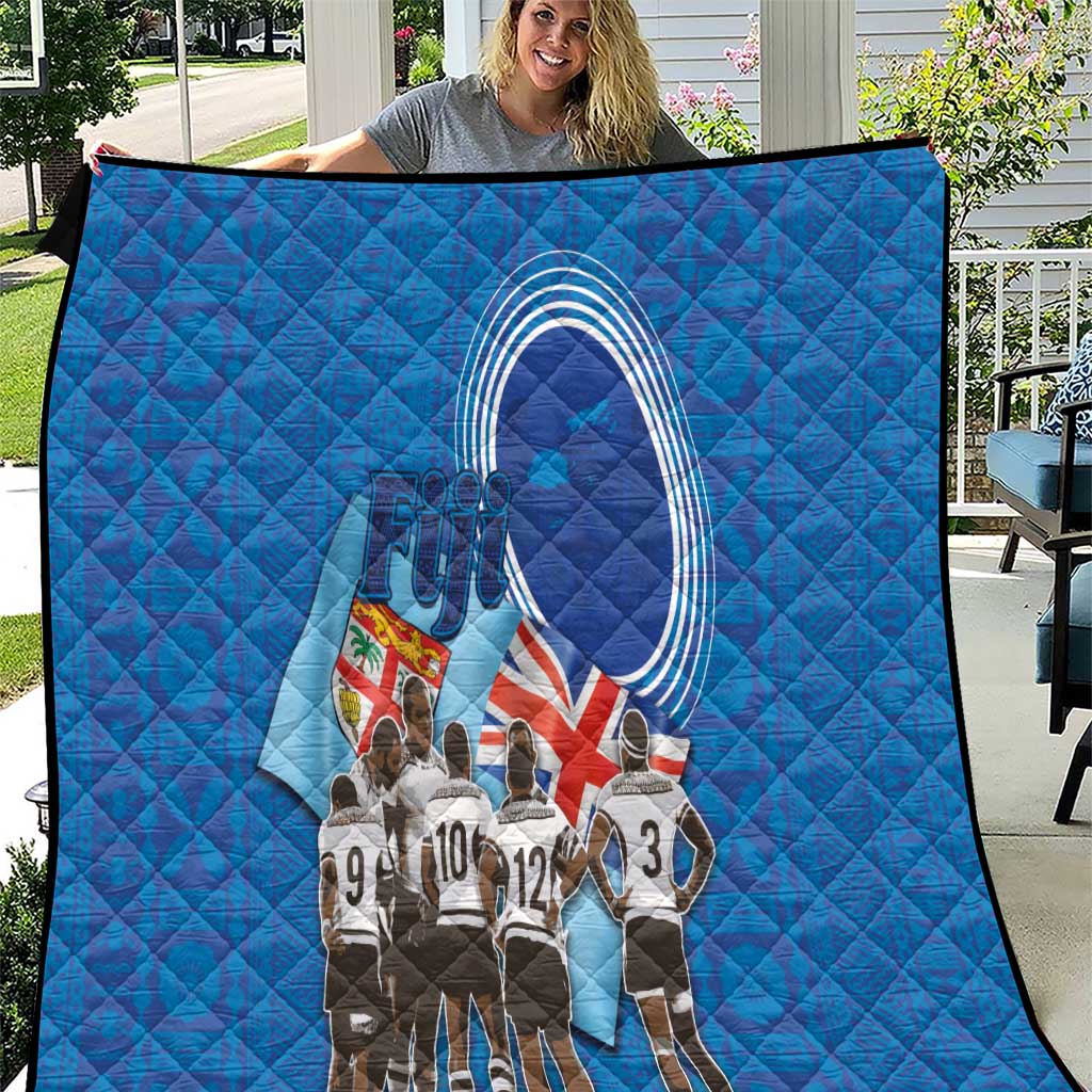 Blue quilt with diamond stitching and rugby team medal arch graphic, outdoors