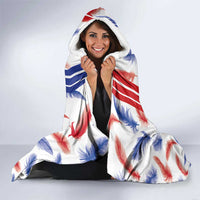 Hooded blanket with white feather print and red/blue stripes, worn with hood up