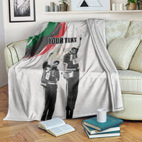 Light gray personalized blanket with green-red brush stripe and black-and-white figures